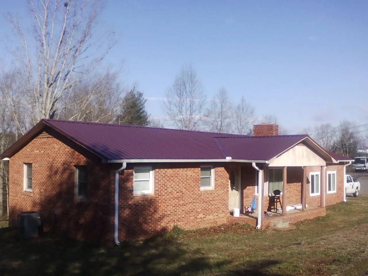 Burgundy metal roof on a brick ranch home with a new addition in Dorothy